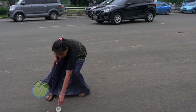Anak-anak bermain bulutangkis di lapangan umum