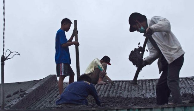 Warga Kecamatan Kandangan membersihkan abu vulkanik dari atap rumah mereka