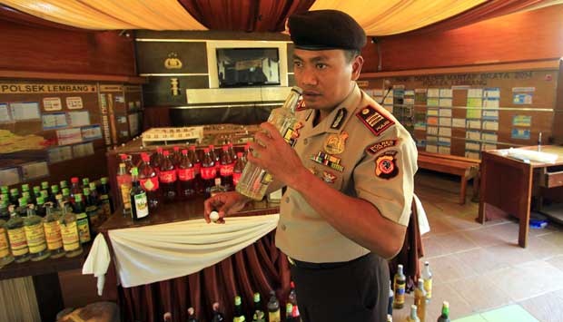 Kapolsek Lembang, AKP Oki Bagus, mencium aroma miras oplosan di Mapolsek Lembang, Jawa Barat, 5 Desember 2014. TEMPO/Aditya Herlambang Putra