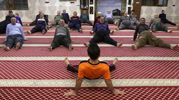 muslim worshipers exercise after the dawn prayer inside a mosque