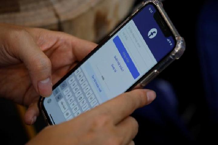 Seorang pengguna Facebook login melalui ponselnya di sebuah kafe di Hanoi, Vietnam 19 November 2020. [REUTERS / Kham]