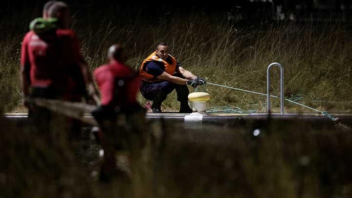 Petugas pemadam kebakaran dan anggota tim pencarian dan penyelamatan melakukan misi untuk memindahkan paus Beluga yang tersesat ke sungai Seine Prancis ke cekungan air asin, di Saint-Pierre-la-Garenne, Prancis, 9 Agustus 2022. Rencananya adalah memindahkan paus yang kekurangan gizi ke kolam air asin dengan harapan dapat memulihkan kekuatannya sebelum dipindahkan ke laut. REUTERS/Benoit Tessier