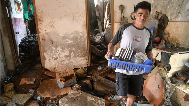 Warga membawa peralatan dapur dari lokasi longsor di Gang Kepatihan, Kelurahan Kalapa, Kota Bogor, Jawa Barat, Rabu, 12 Oktober 2022. Rumah warga ikut terdampak material longsoran tebing. ANTARA FOTO/Arif Firmansyah