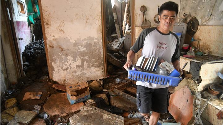 Warga membawa peralatan dapur dari lokasi longsor di Gang Kepatihan, Kelurahan Kalapa, Kota Bogor, Jawa Barat, Rabu, 12 Oktober 2022. Rumah warga ikut terdampak material longsoran tebing. ANTARA FOTO/Arif Firmansyah 