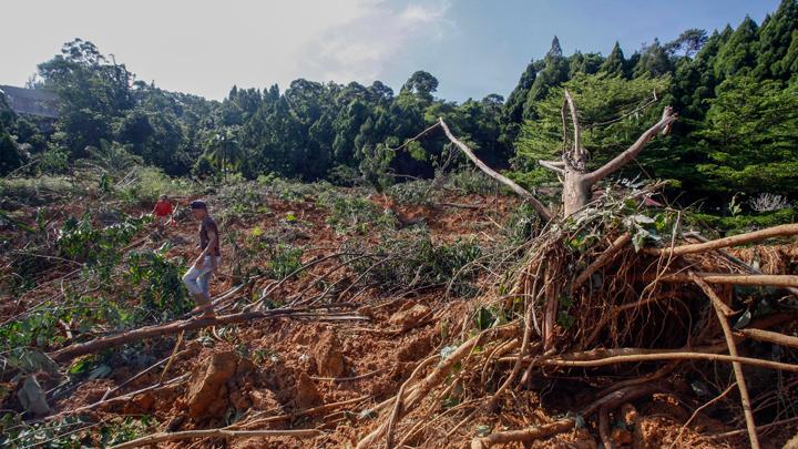 Warga melintasi reruntuhan material longsor di Desa Gunung Geulis, Sukaraja, Kabupaten Bogor, Jawa Barat, Jumat, 14 Oktober 2022. ANTARA FOTO/Yulius Satria Wijaya