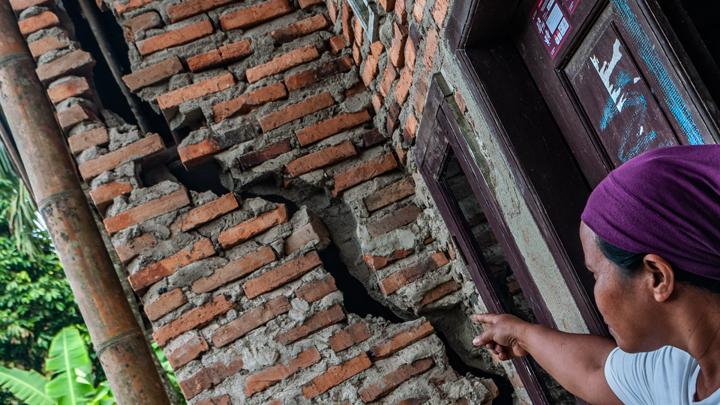 Warga memantau retakan di lantai rumah akibat tanah bergerak