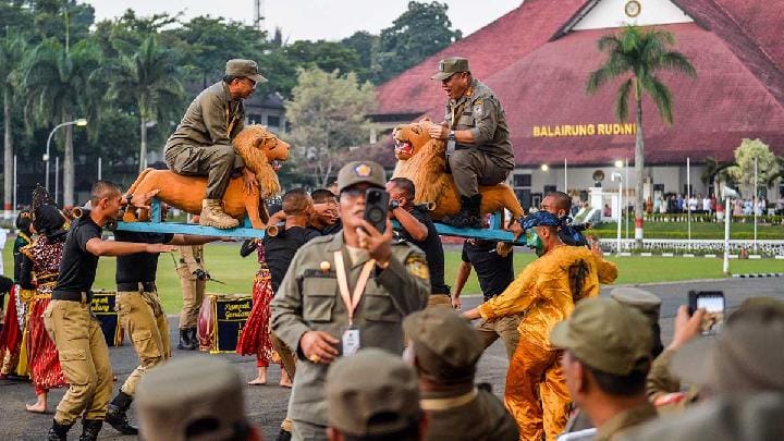 Gubernur Provinsi Bali I Wayan Koster (kiri) bersama Gubernur Provinsi Bangka Belitung Hidayat Arsani (kanan) menaiki sisingaan pada upacara penutupan retret kepala daerah di Kampus IPDN, Jatinangor, Sumedang, Jawa Barat, 26 Juni 2025.  Antara/Raisan Al Farisi