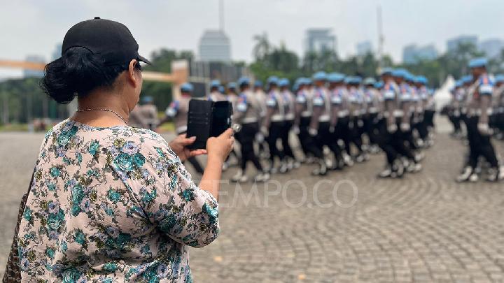 Sejumlah warga berwisata sekaligus menyaksikan gladi Hari Ulang Tahun Bhayangkara ke-79 di kawasan Monumen Nasional, Jakarta, 28 Juni 2025. Tempo/Dandi Bajuddin