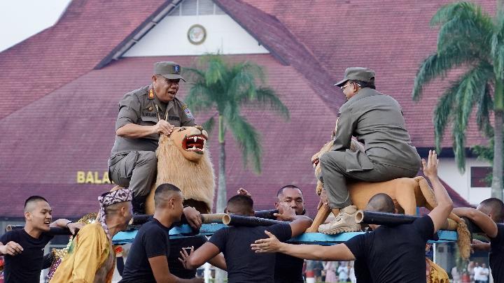Gubernur Provinsi Bali I Wayan Koster (kanan) bersama Gubernur Provinsi Bangka Belitung Hidayat Arsani (kiri) menaiki sisingaan pada upacara penutupan retret kepala daerah di Kampus IPDN, Jatinangor, Sumedang, Jawa Barat, 26 Juni 2025. TEMPO/Hendy Mulia