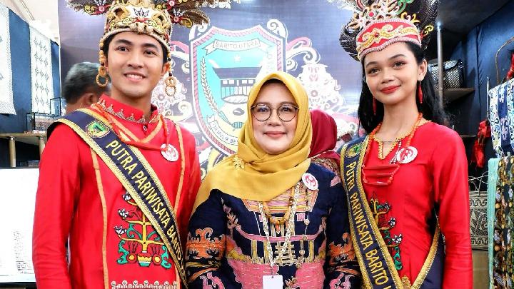Ketua Dekranasda Barito Utara Melly Novita Indra Gunawan berfoto bersama Putra dan Putri Pariwisata Barito Utara di stan Dekranasda Barito Utara dalam acara HUT ke-45 Dekranas di Balikpapan, Kalimantan Timur, pada Rabu, 9 Juli 2025. Dok. TEMPO