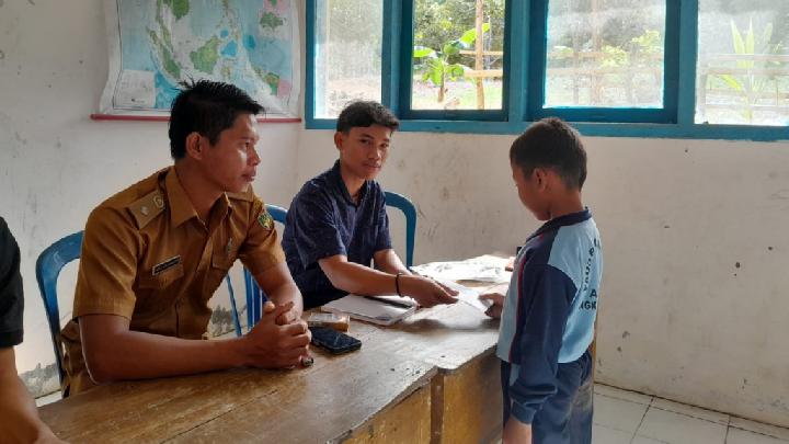 Kepala Desa Air Tenam Miki Aleksander dan pengelola pohon asuh menyerahkan beasiswa kepada Siswi SDN 115 Kecamatan Ulu Manna Kabupaten Bengkulu Selatan (Foto: Warsi)