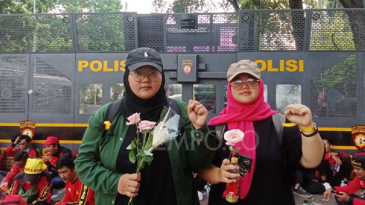 Mahasiswa Bagikan Bunga Pink dan Hijau kepada Massa Demo Buruh