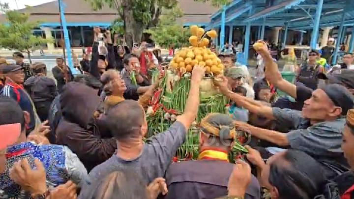 Ratusan warga antusias berebut isi gunungan dalam tradisi Grebeg Pasa yang digelar Keraton Surakarta, Jawa Tengah, 22 Maret 2026. Tempo/Septhia Ryanthie
